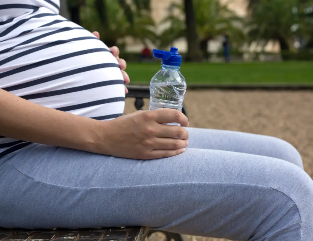 Pregnant woman drinking glucose drink for gestational diabetes test