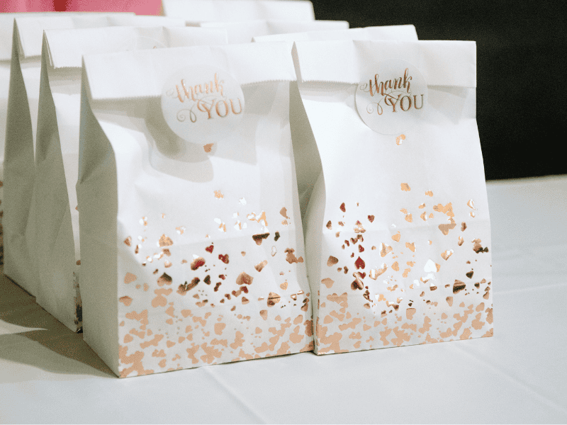 Paper bags filled with homemade flavored popcorn and topped with cute tags, perfect as simple and creative baby shower favors.
