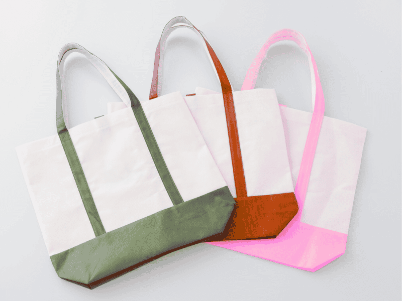 Foldable reusable shopping bags in fun patterns, displayed as eco-friendly baby shower party favor ideas.