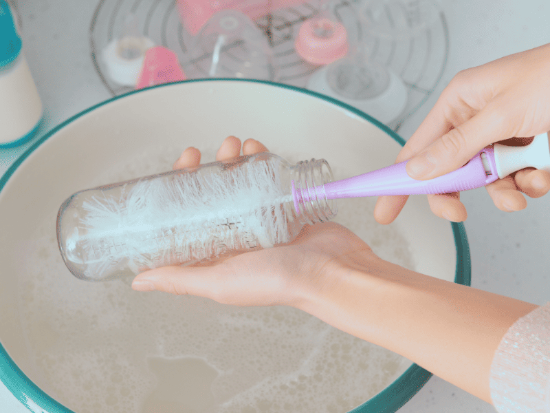 Cleaning brushes at the sink during a nesting baby shower
