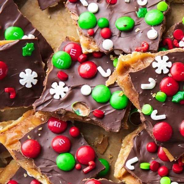 Christmas Crack made with saltine crackers, toffee, and melted chocolate, topped with holiday sprinkles and candy.