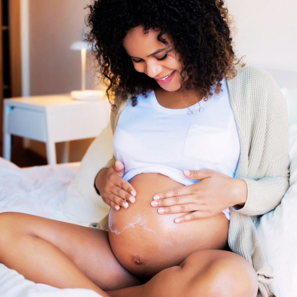 A pregnant mom gently rubbing her belly, representing pregnancy tips, baby shower planning, and expecting mom resources.