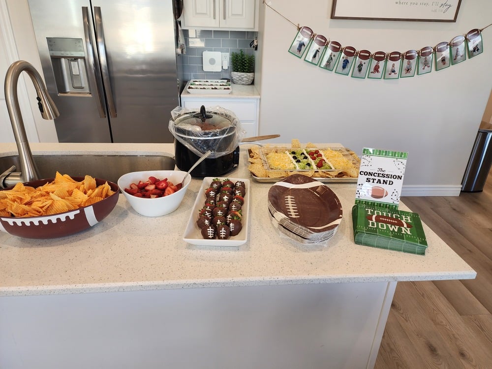 Football-themed party snacks arranged on a table, including treats styled to look like footballs.